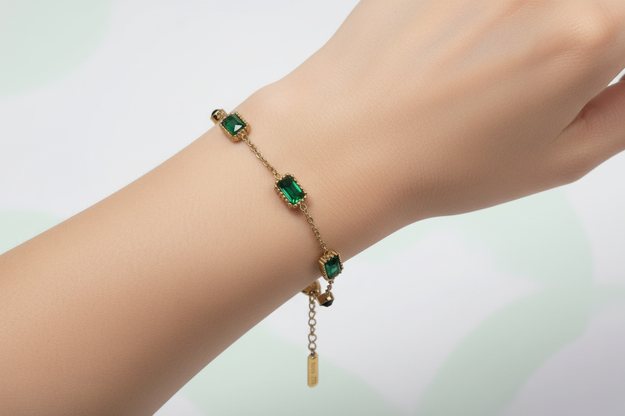Gold bracelet with green gemstones on a light gradient background
