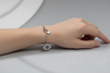 Silver bracelet with an eye-shaped pendant on a light gray surface