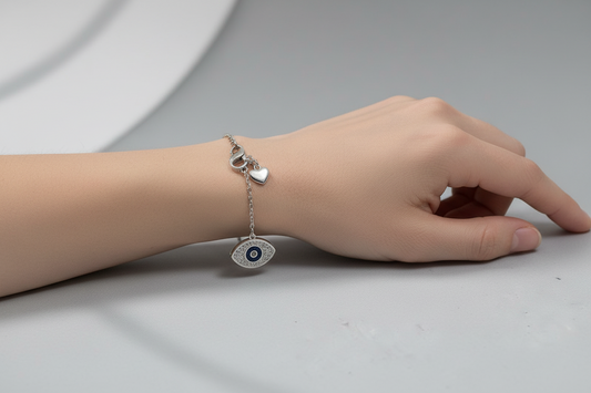 Silver bracelet with an eye-shaped pendant on a light gray surface