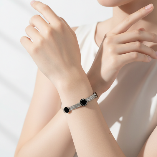 Silver bracelet with black accents on a white surface