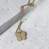 Gold butterfly necklace on a textured surface