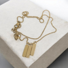 Gold necklace with pendant on a white cushion