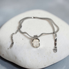 Silver necklace with a pendant on a white stone