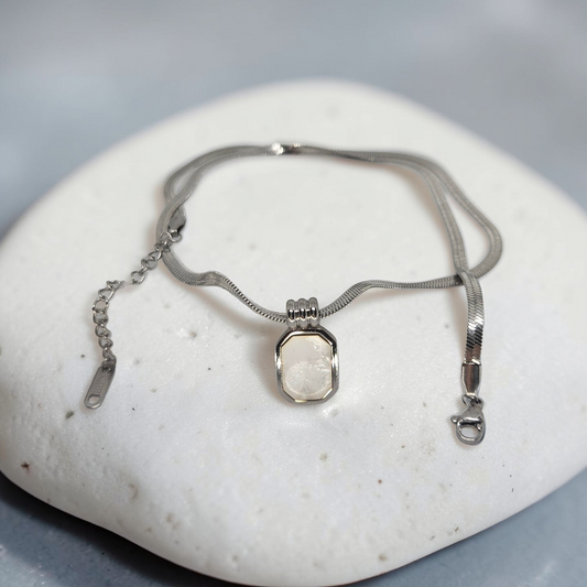 Silver necklace with a pendant on a white stone