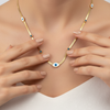 Gold necklace with blue eye-shaped charms on a gray background