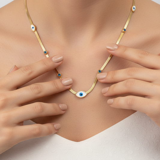Gold necklace with blue eye-shaped charms on a gray background