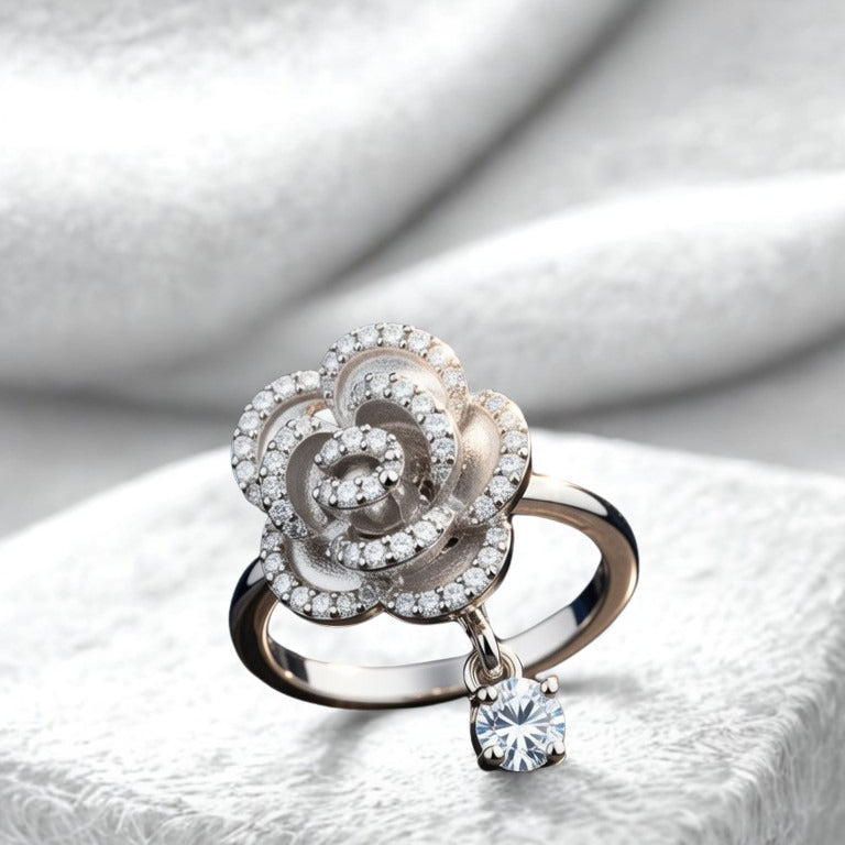 Silver ring with floral design and diamond on a white stone surface