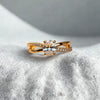 Gold ring with a diamond on a textured white surface