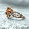 Rose gold ring with floral design on a textured surface