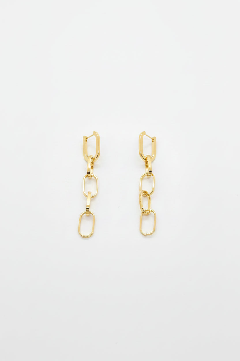 A pair of gold-toned drop earrings with geometric links and elongated oval charms, displayed on a white surface.