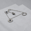 Silver bracelet with an eye-shaped pendant on a light gray surface