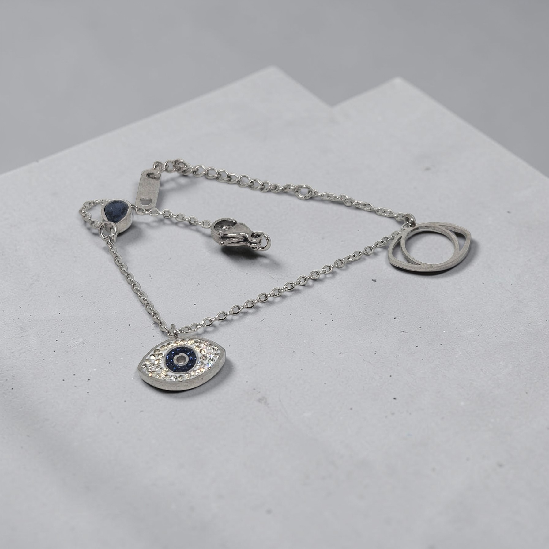 Silver bracelet with an eye-shaped pendant on a light gray surface
