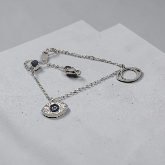 Silver bracelet with an eye-shaped pendant on a light gray surface