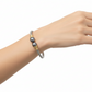 Bracelet with gray beads and gold accents on a light background