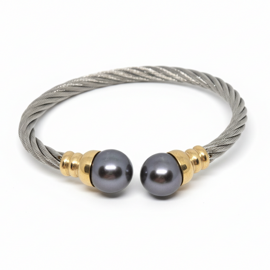Bracelet with gray beads and gold accents on a gray background