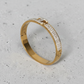 Gold bracelet with diamond accents on a concrete surface