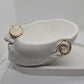 A pair of textured gold hoop earrings displayed on a white sculptural head-shaped jewelry stand against a plain white background.