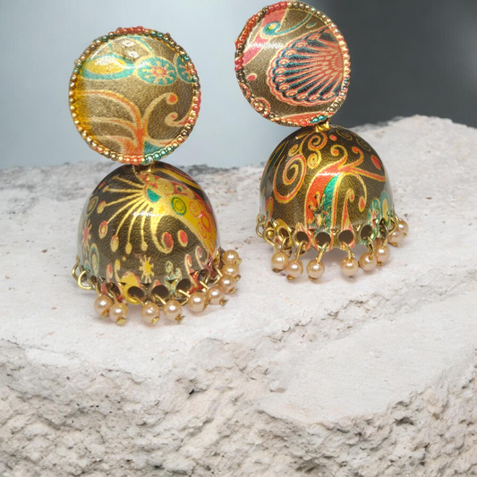 Decorative earrings with intricate designs on a textured surface