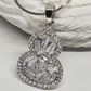 Silver necklace with a detailed pendant on a textured white surface