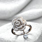 Silver ring with floral design and diamond on a white stone surface