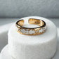 Gold and white ring on a white stand with a gray background