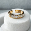 Gold and white ring on a white stand with a gray background