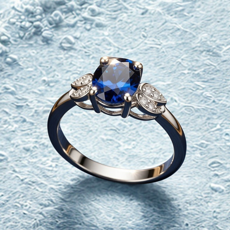 Silver ring with a blue gemstone and smaller diamonds on a textured light blue background