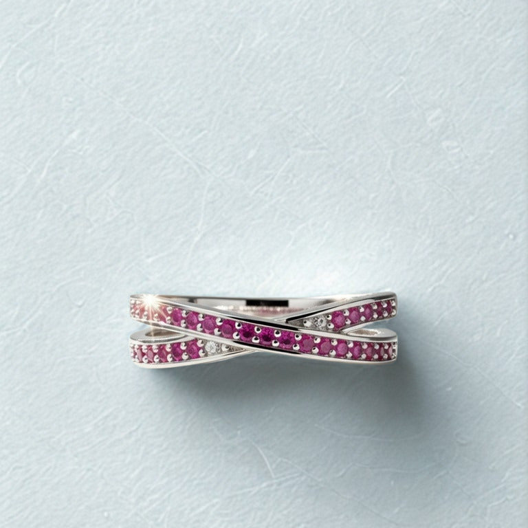 Silver ring with pink gemstones on a light gray background