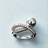 Silver ring with a pearl on a light blue background