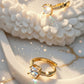 Gold rings with diamonds on a textured white surface, featuring the brand 'Zylva'.