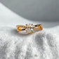 Gold ring with a diamond on a textured white surface