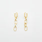 A pair of gold-toned drop earrings with geometric links and elongated oval charms, displayed on a white surface.