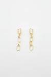 A pair of gold-toned drop earrings with geometric links and elongated oval charms, displayed on a white surface.