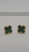 A pair of gold-tone stud earrings with green striped inlay, photographed on a plain light gray surface.