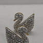 A pair of swan-shaped stud earrings covered in clear rhinestones with gold-tone outlines, displayed on a plain light gray surface.