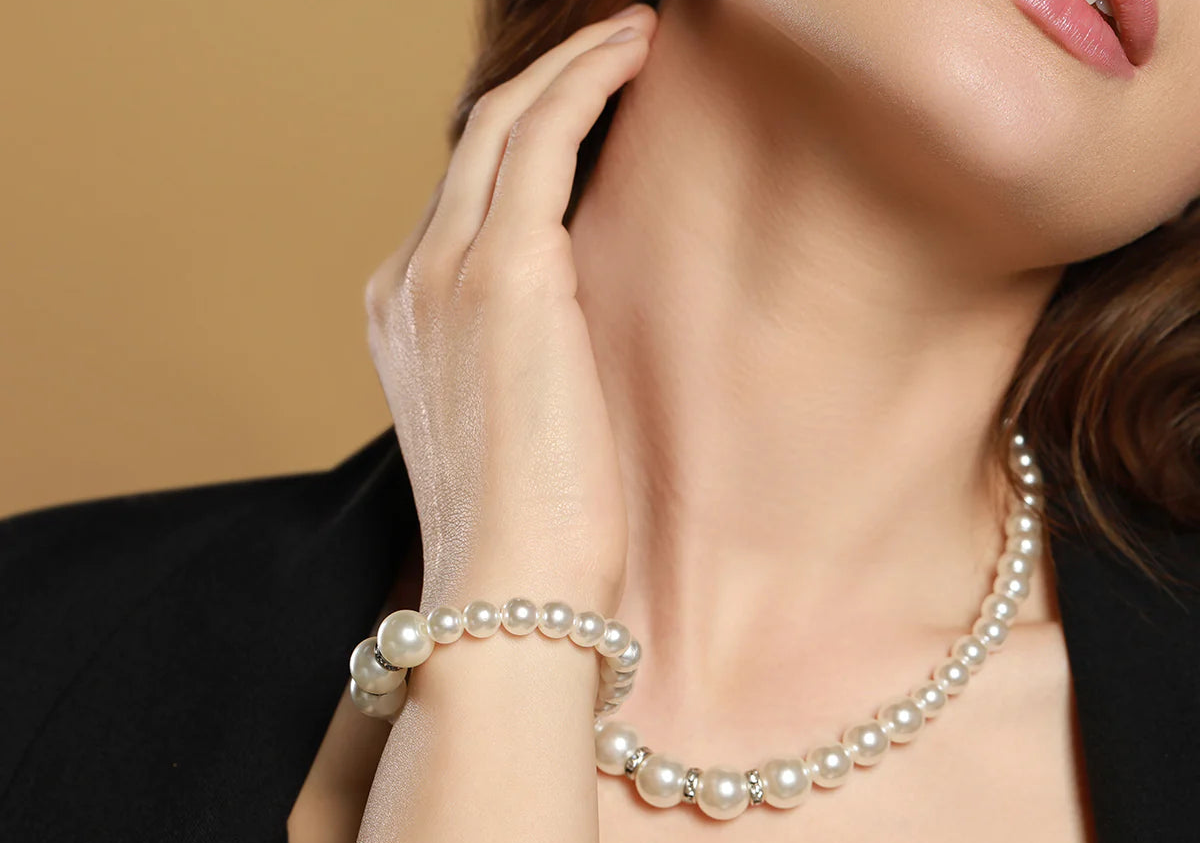 Pearl necklace worn by a model against a beige background