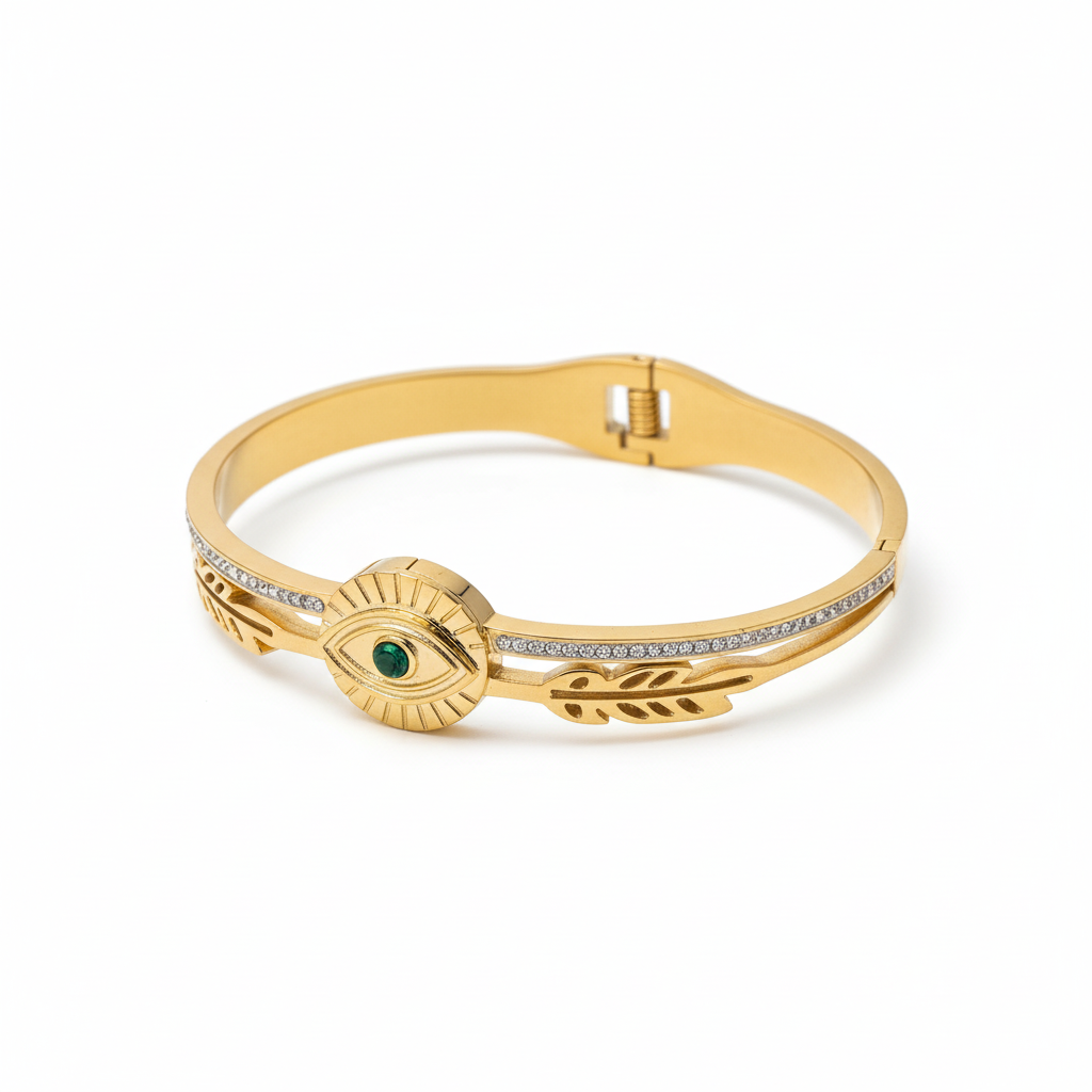 Gold bracelet with eye design and green gemstone on a white background